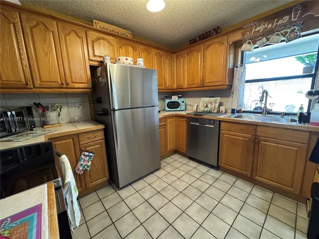 a kitchen with stainless steel appliances granite countertop a refrigerator sink and cabinets