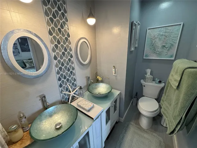 a bathroom with a toilet a sink and mirror