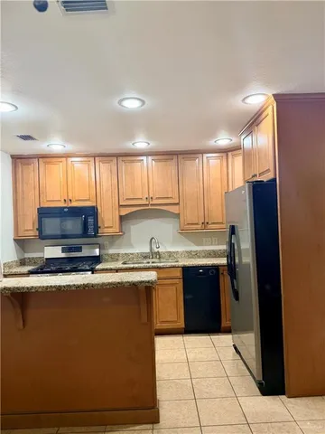 a kitchen with stainless steel appliances granite countertop a stove a sink and a refrigerator