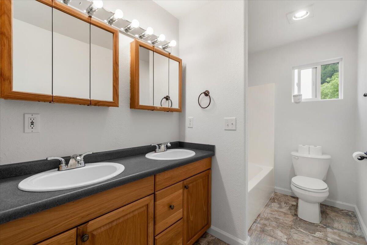 1196 Freshwater Road Eureka, CA 95503 - Photo 22 of 34 a bathroom with a granite countertop sink toilet and a mirror