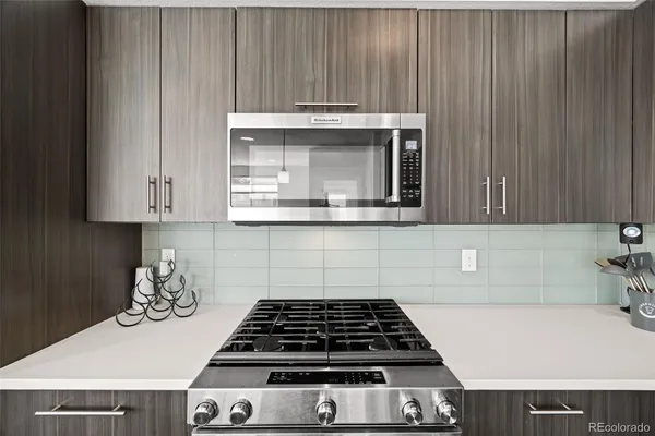 a kitchen with granite countertop a stove and a white cabinet