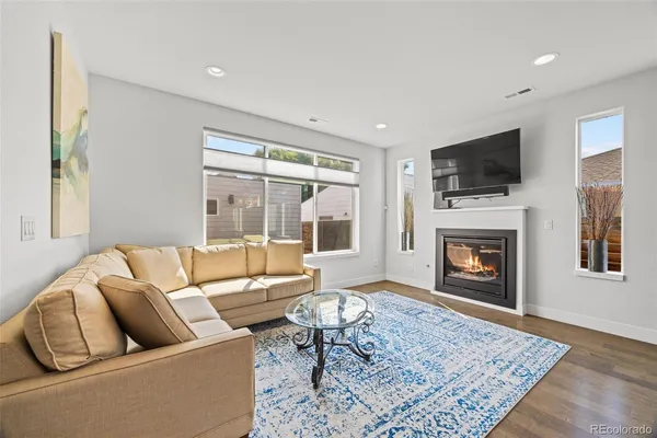 a living room with furniture a flat screen tv and a fireplace