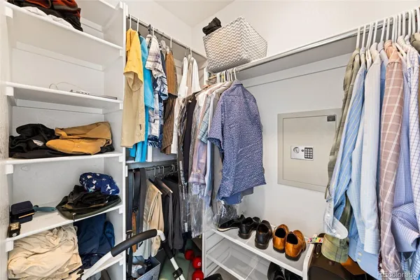 a view of walk in closet with clothes and shoes