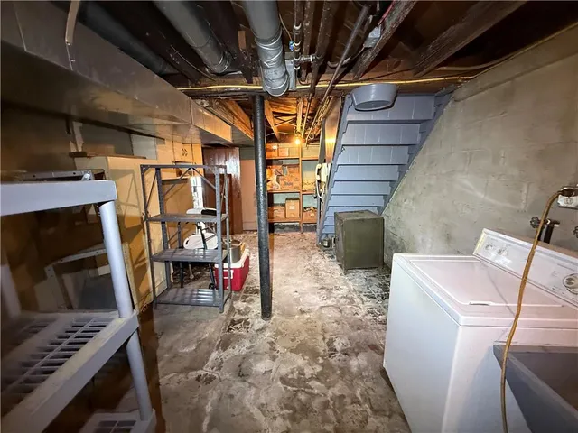 a utility room with dryer washer and stair