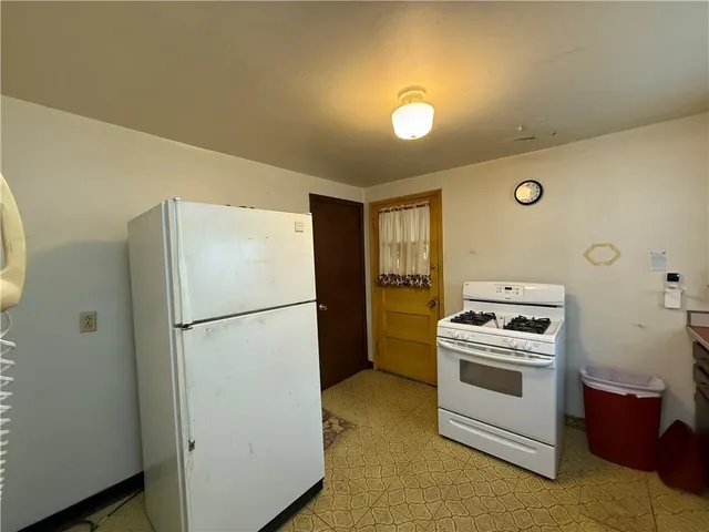 a white refrigerator freezer and a stove sitting inside of a kitchen