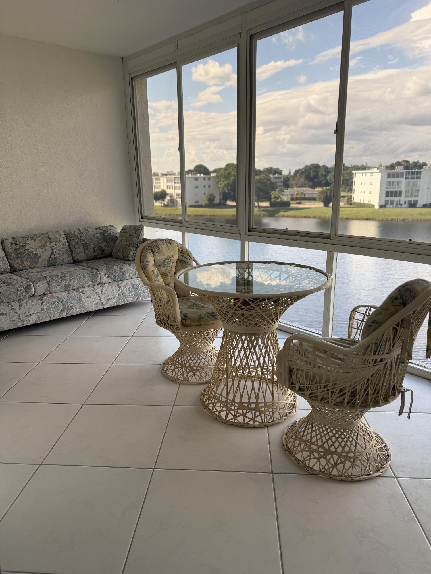 a dining room with furniture and floor to ceiling windows
