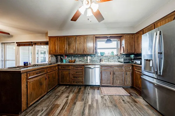 a kitchen with stainless steel appliances granite countertop a stove a sink and a refrigerator