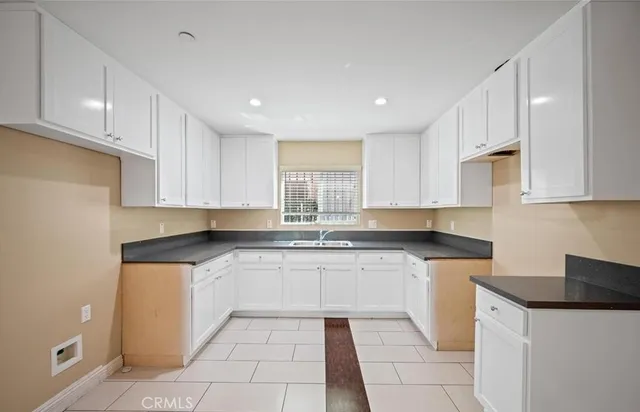 a kitchen with stainless steel appliances granite countertop a sink and white cabinets