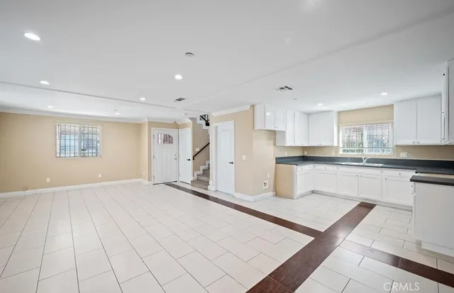 a kitchen with stainless steel appliances kitchen island sink refrigerator and cabinets