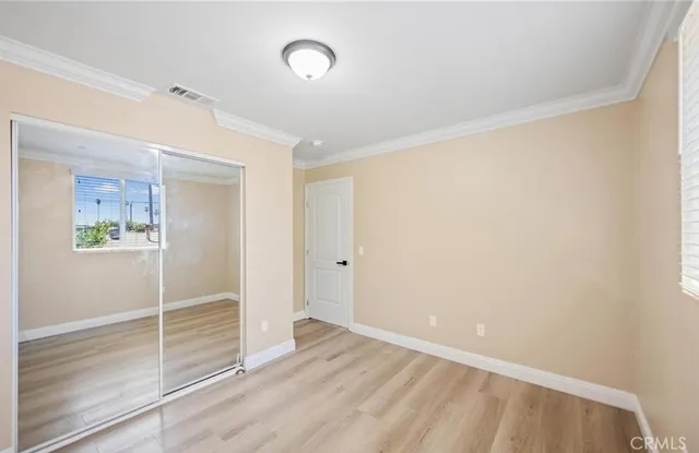 a view of a room with wooden floor and white walls