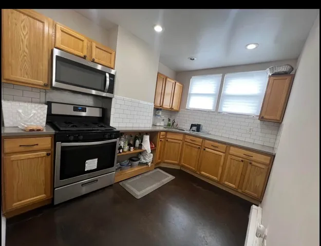 a kitchen with stainless steel appliances a stove sink and microwave