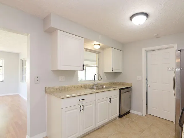 a kitchen with a sink cabinets and a window