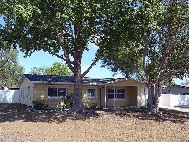 a front view of a house with a tree