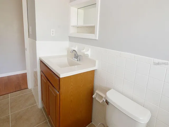 a bathroom with a sink toilet and mirror