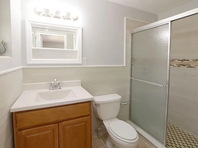 a bathroom with a sink toilet vanity and shower