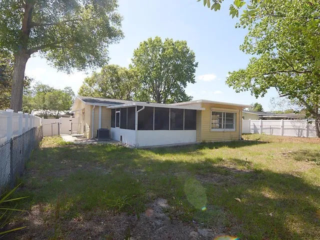 a view of a yard in front of a house with a large tree