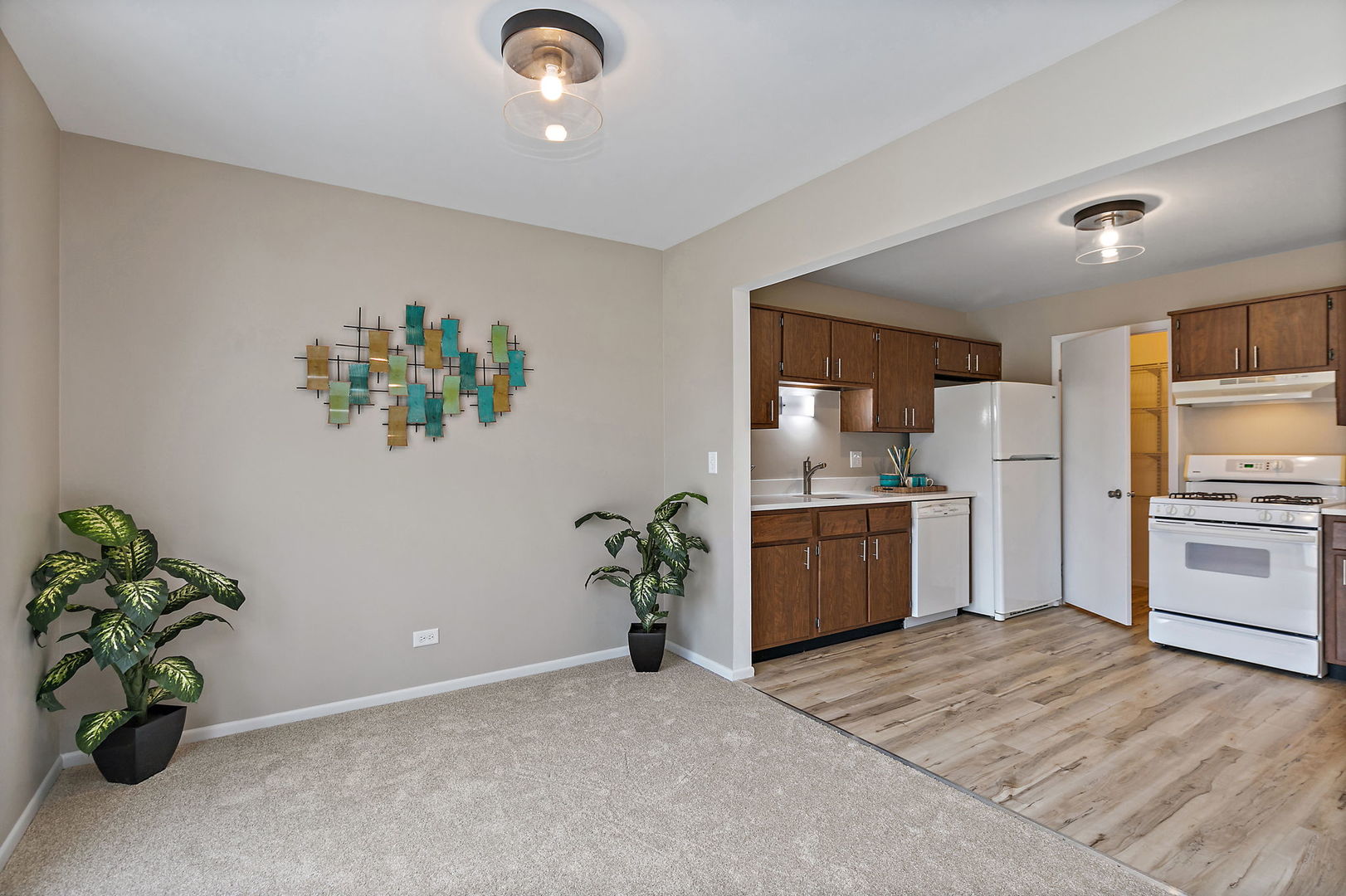 218 Deerpath Court, Unit B2 Schaumburg, IL 60193 - Photo 7 of 21 a white kitchen with a stove a refrigerator and a potted plant