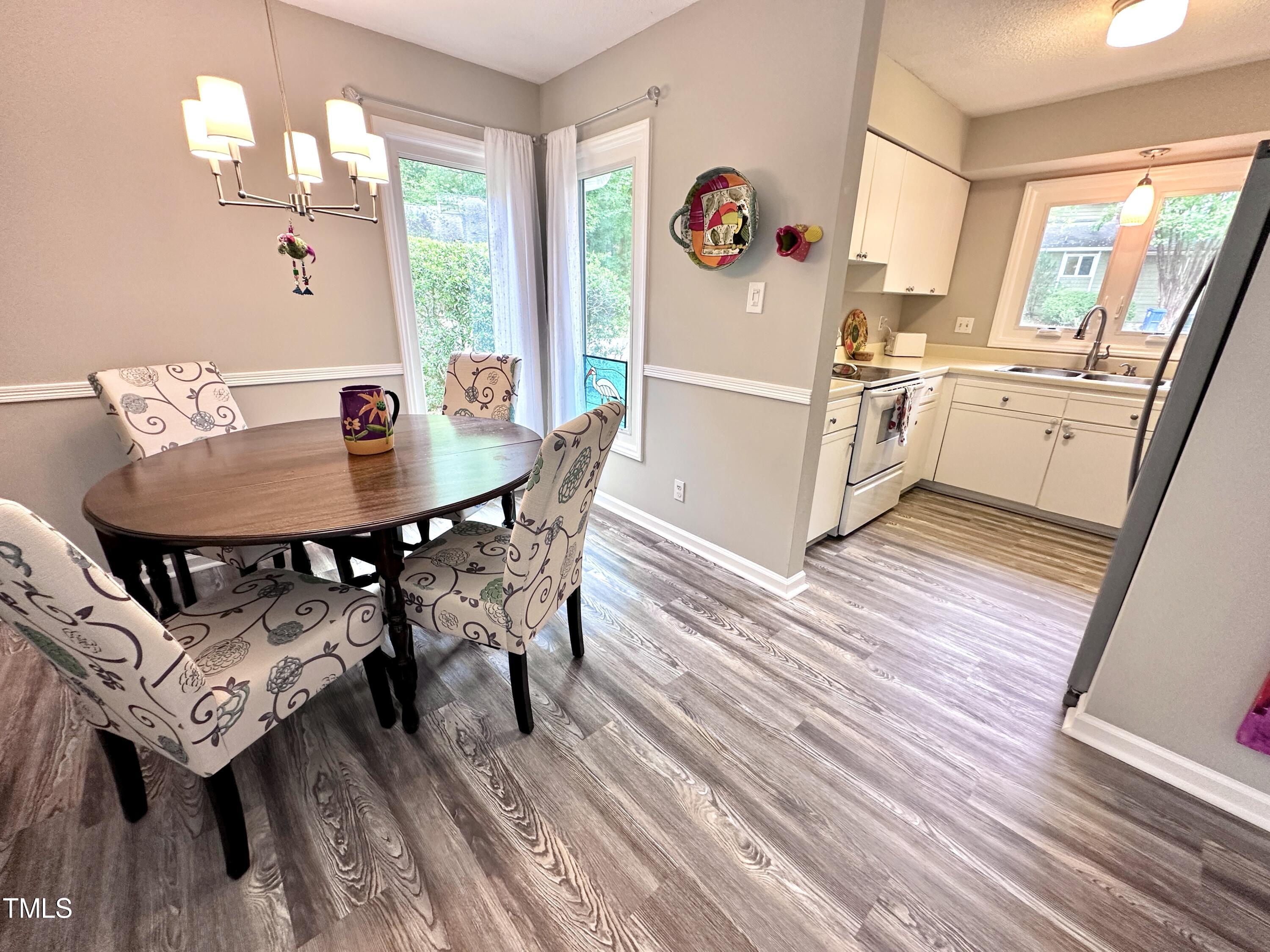 4311 Beechnut Lane Durham, NC 27707 - Photo 23 of 56 a kitchen with a table chairs and a refrigerator