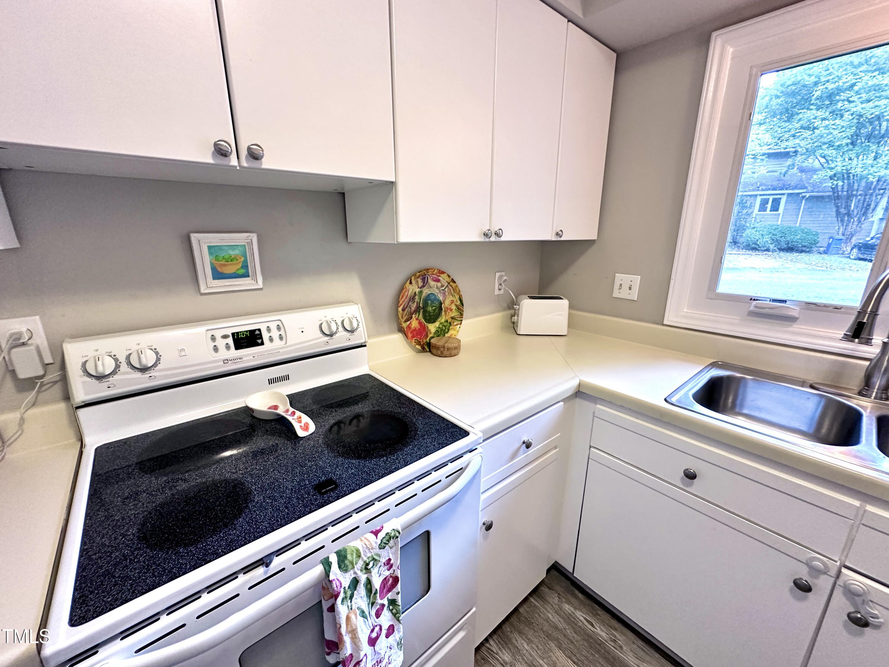 4311 Beechnut Lane Durham, NC 27707 - Photo 25 of 56 a kitchen with a sink stove and cabinets