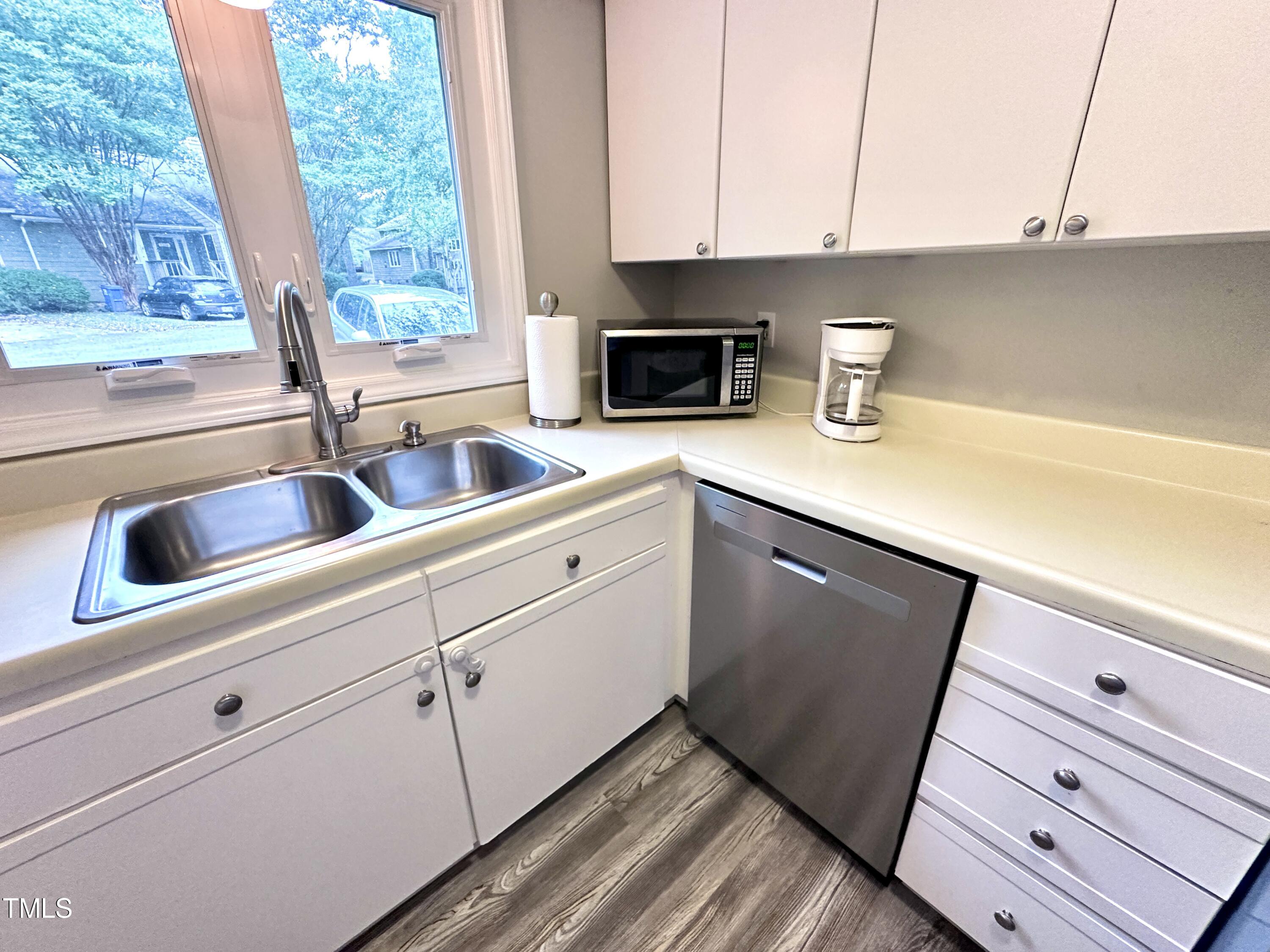 4311 Beechnut Lane Durham, NC 27707 - Photo 27 of 56 a kitchen with white cabinets and a sink