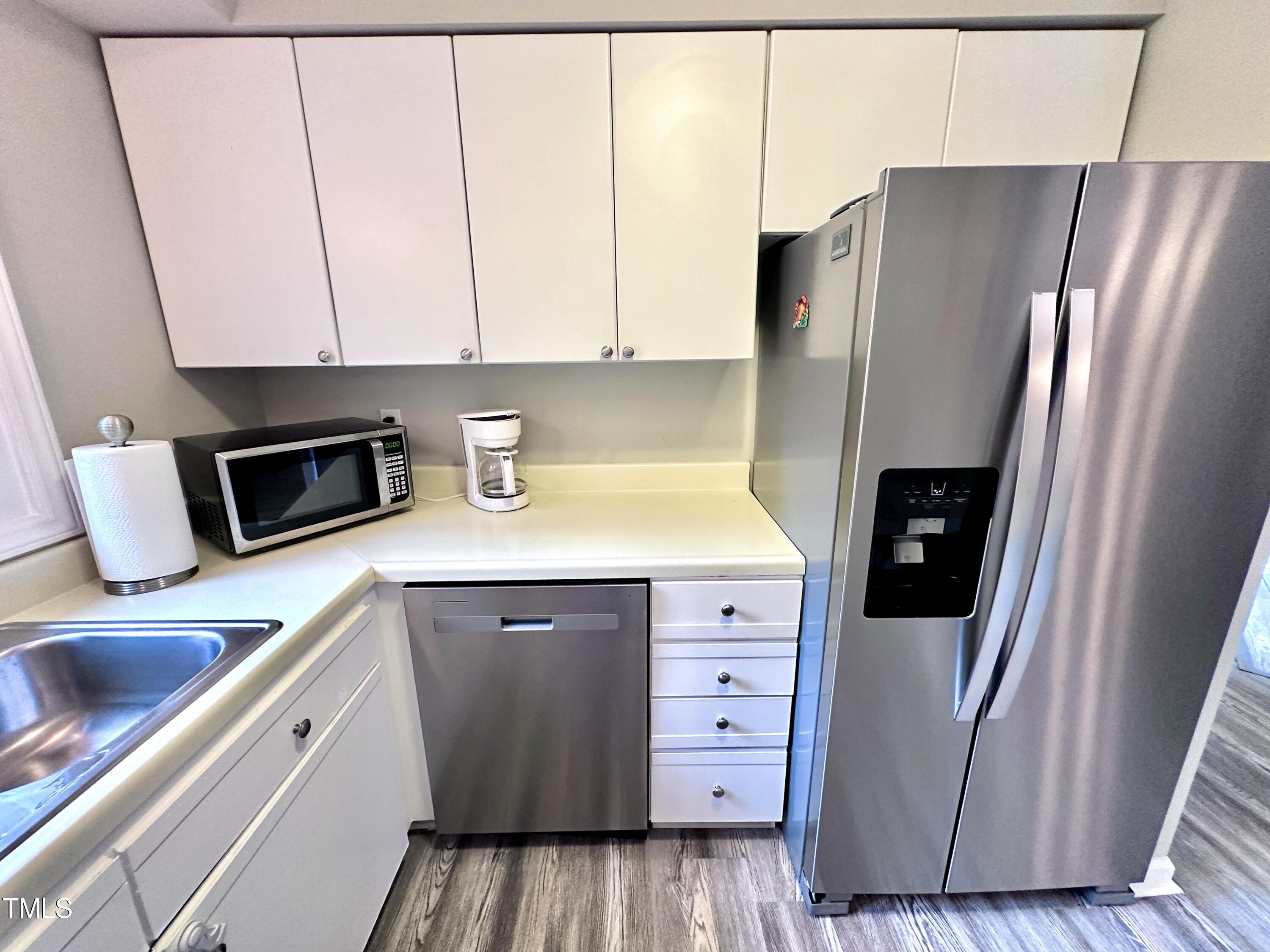4311 Beechnut Lane Durham, NC 27707 - Photo 28 of 56 a kitchen with granite countertop a refrigerator and a sink