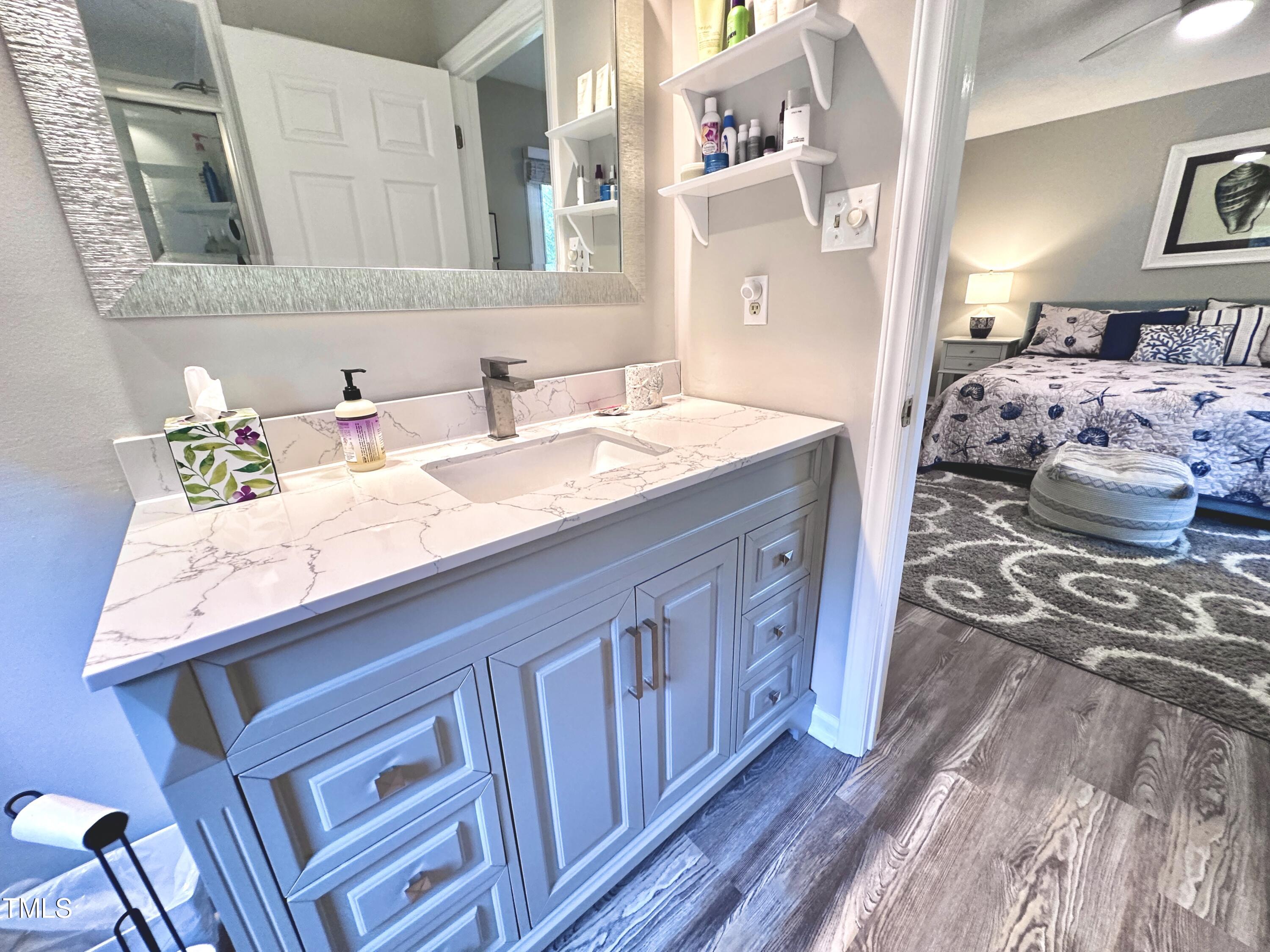 4311 Beechnut Lane Durham, NC 27707 - Photo 33 of 56 a en suite bathroom with a granite countertop sink and a mirror
