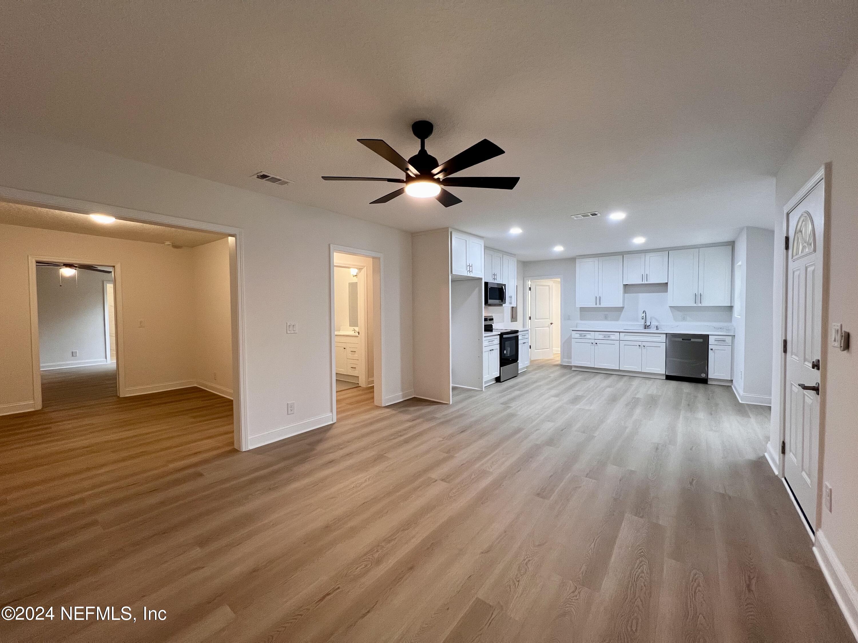 1833 Bartram Road Jacksonville, FL 32207 - Photo 14 of 50 a view of an empty room and a kitchen with wooden floor
