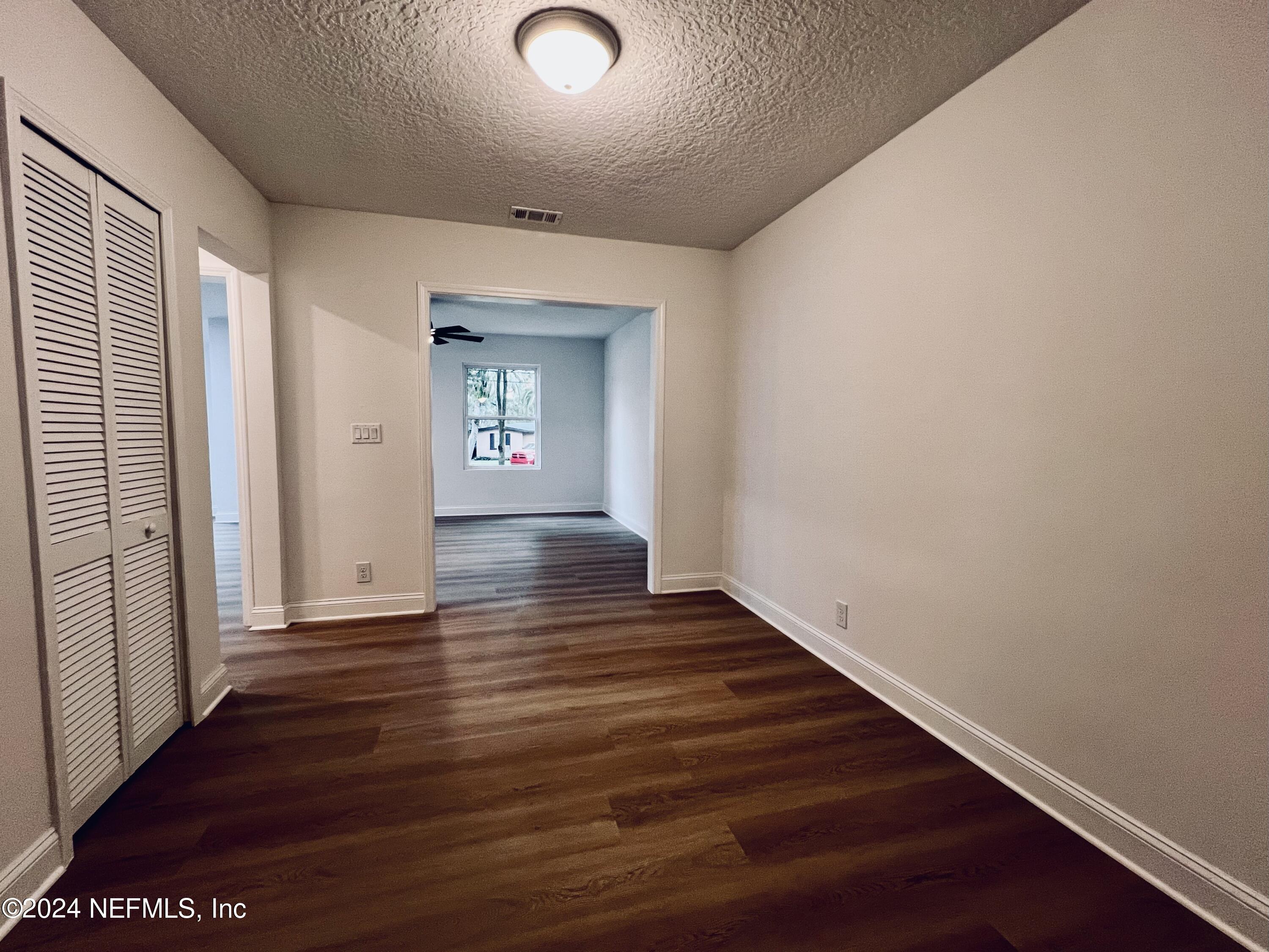 1833 Bartram Road Jacksonville, FL 32207 - Photo 20 of 50 a view of an empty room with wooden floor and a window