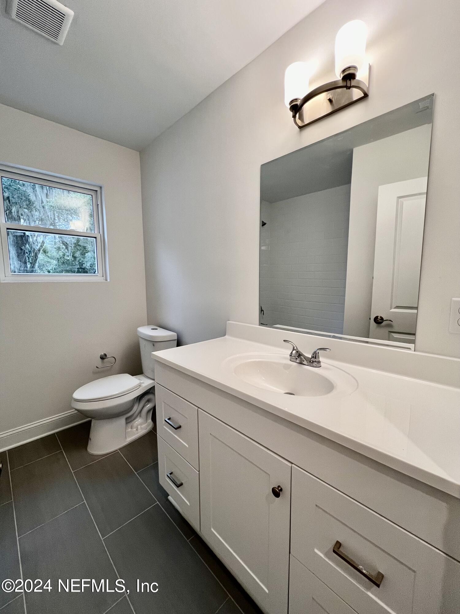 1833 Bartram Road Jacksonville, FL 32207 - Photo 22 of 50 a bathroom with a toilet a sink and mirror