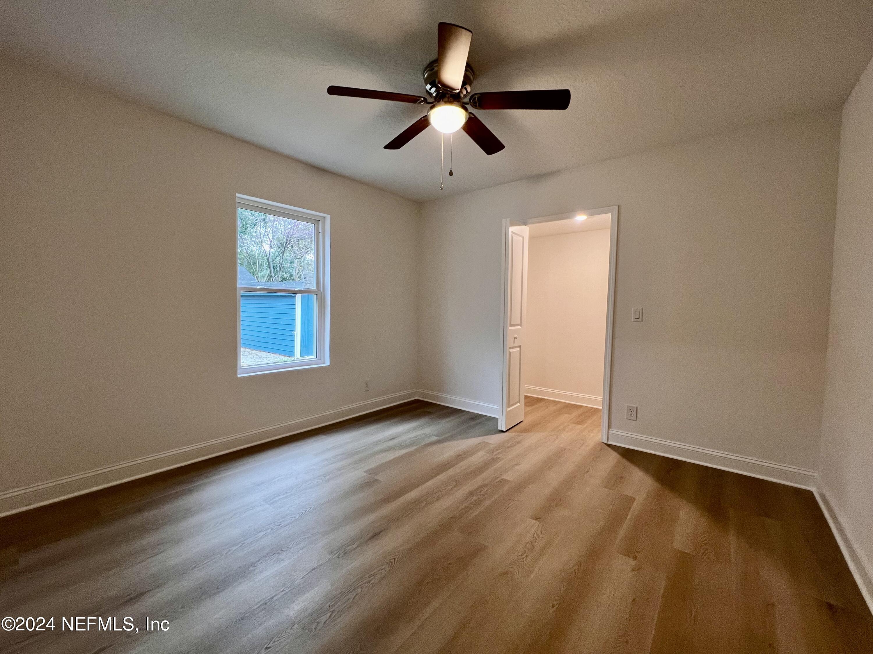 1833 Bartram Road Jacksonville, FL 32207 - Photo 25 of 50 an empty room with wooden floor chandelier fan and windows