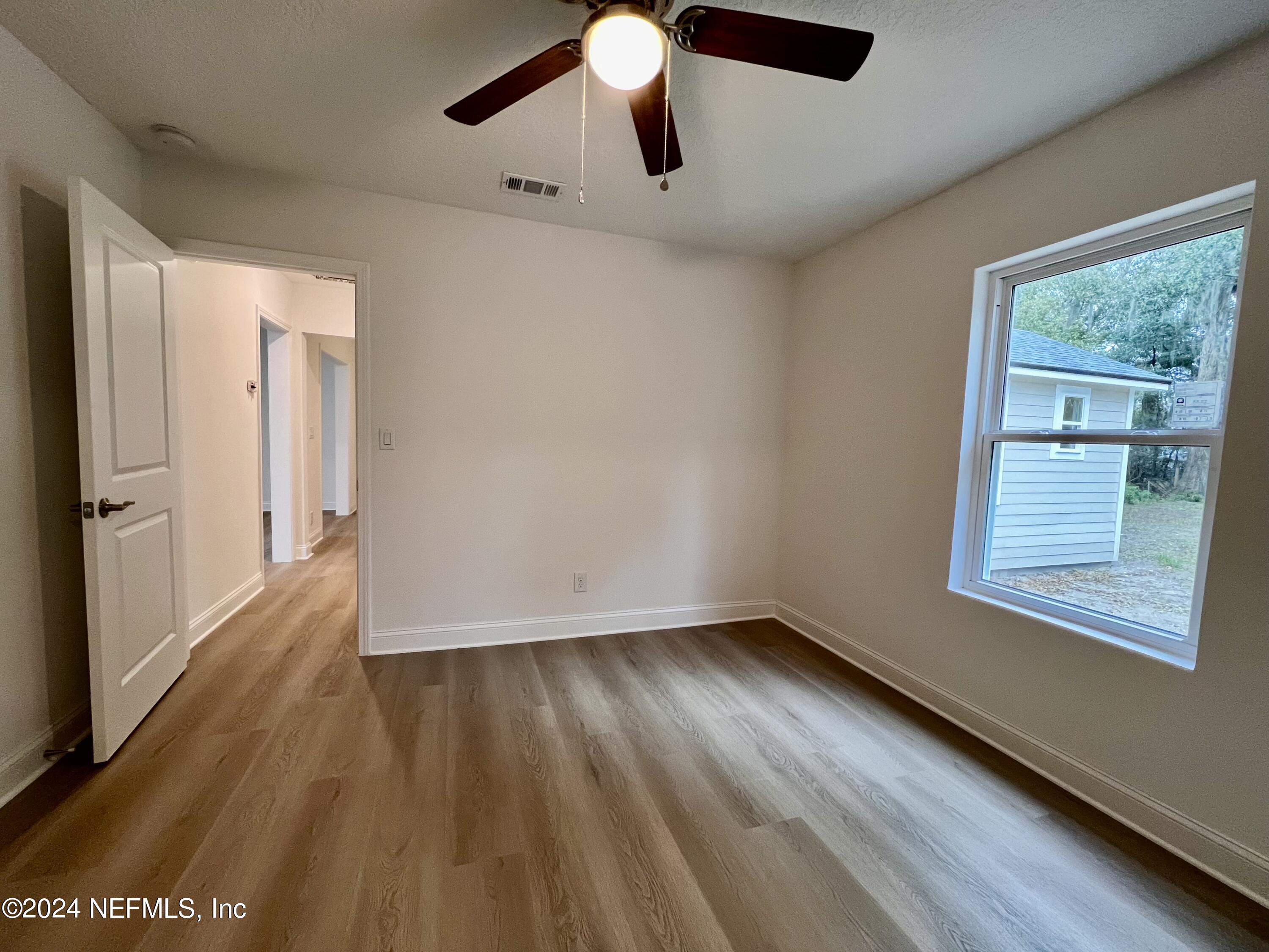 1833 Bartram Road Jacksonville, FL 32207 - Photo 26 of 50 a view of an empty room with wooden floor and a window