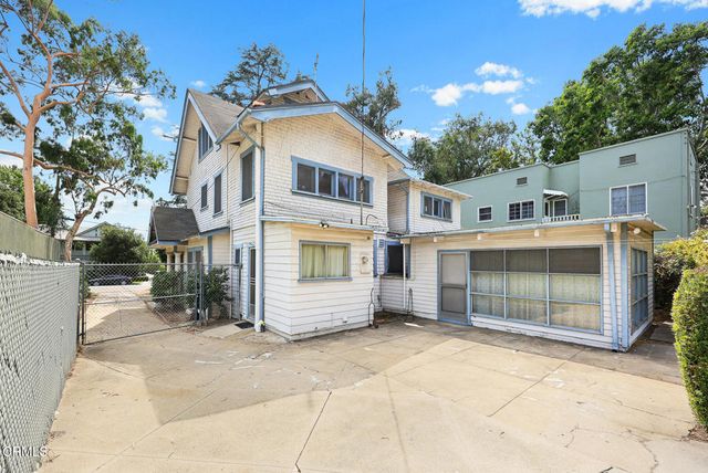 a white house that has a tree in front of it