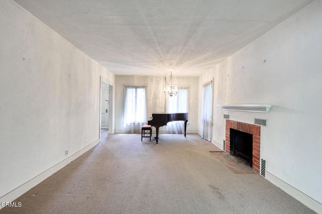 a view of a livingroom with a fireplace and window