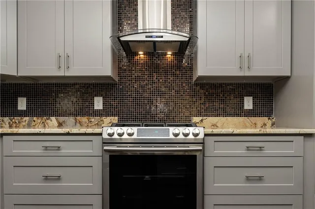 a large kitchen with kitchen island a stove a sink dishwasher and white cabinets with wooden floor