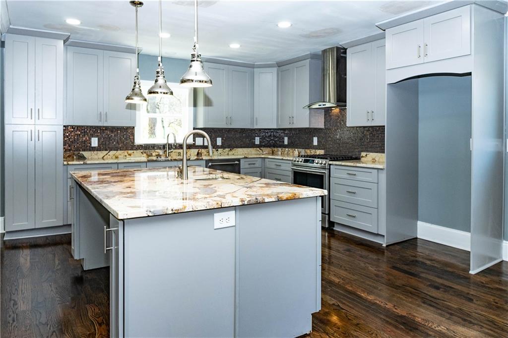 1433 Merriman Lane Northeast Atlanta, GA 30324 - Photo 23 of 60 a kitchen with kitchen island granite countertop a sink cabinets and refrigerator