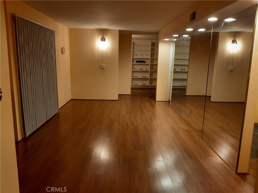 12592 Montecito Road, Unit 9 Seal Beach, CA 90740 - Photo 6 of 16 an empty room with wooden floor and closet