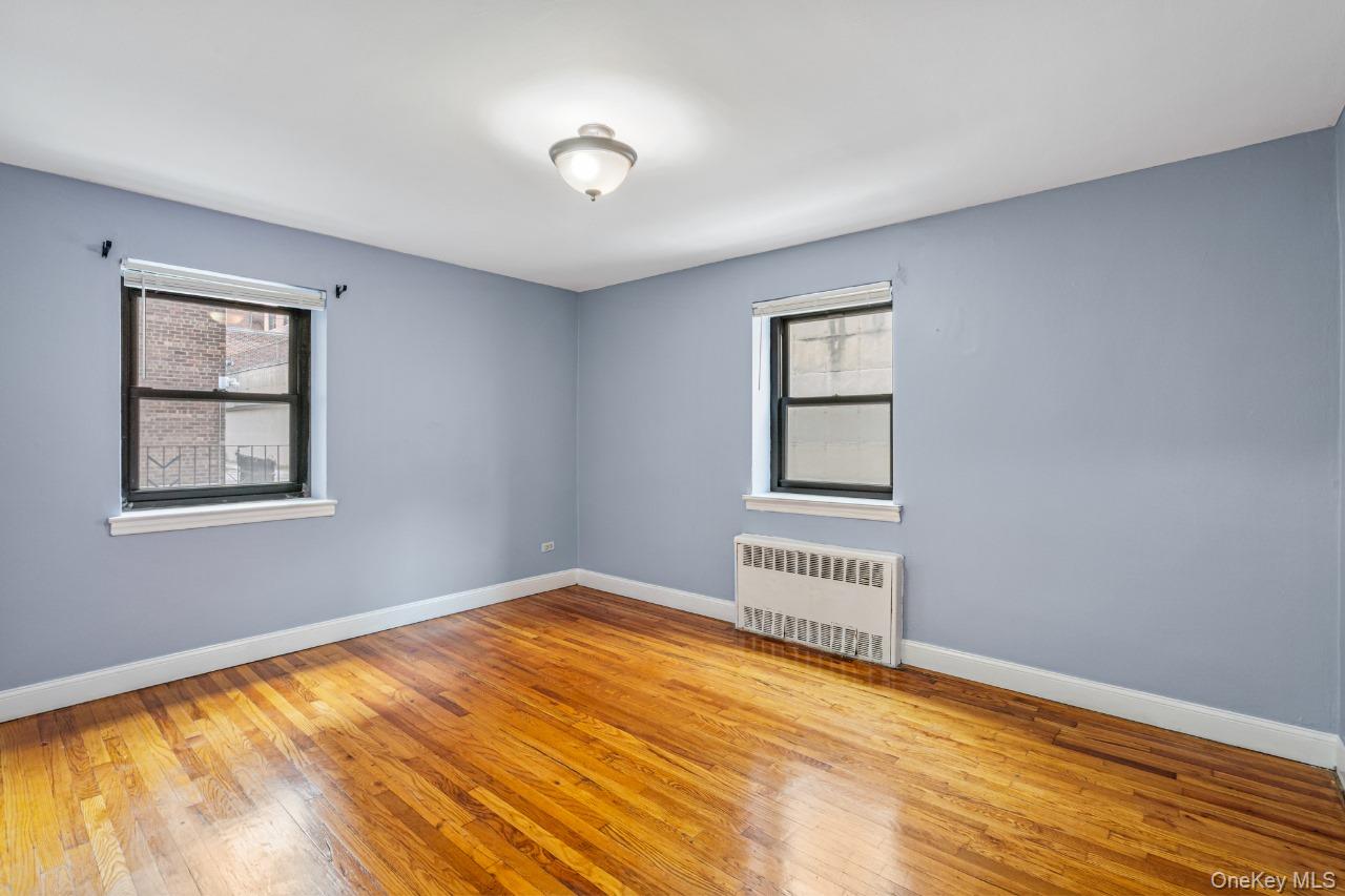 102-55 67th Road, Unit 2V Queens, NY 11375 - Photo 10 of 14 a view of an empty room with wooden floor and a window