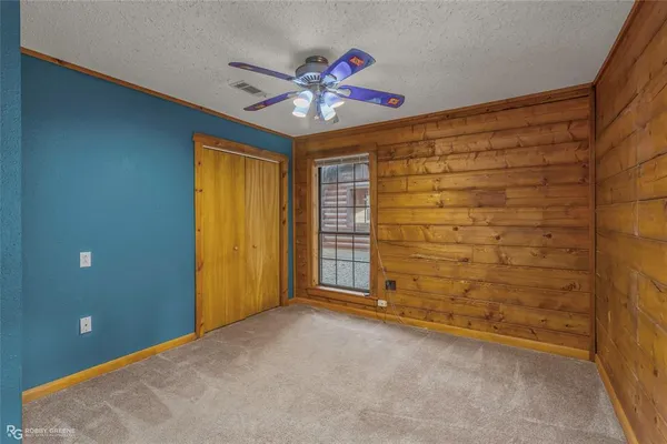 a view of empty room with window and a chandelier fan