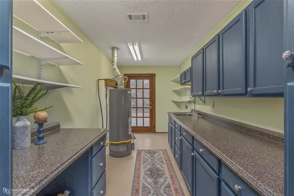 a view of a house with a yard and large trees