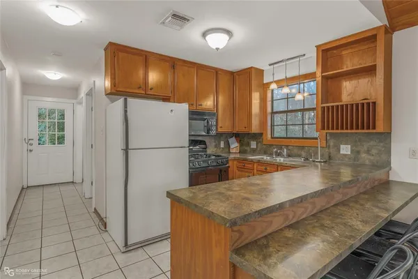 a kitchen with granite countertop a sink stove and cabinets