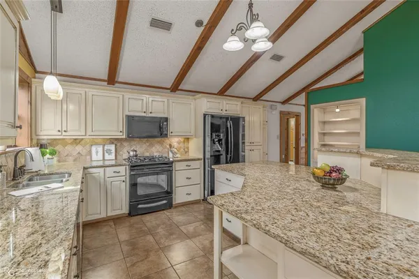 a kitchen with cabinets and chandelier