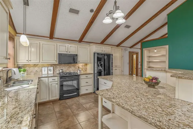 a kitchen with cabinets and chandelier