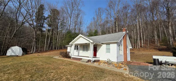 a view of a house with backyard and trees