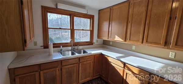 a kitchen with a sink a counter top space and cabinets
