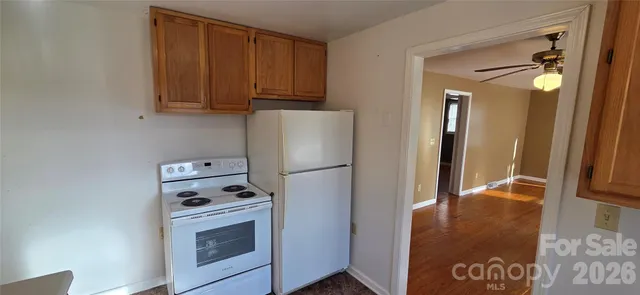 a view of kitchen with refrigerator stove and window