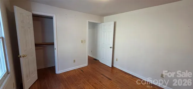 an empty room with wooden floor and closet