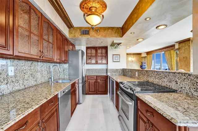 a kitchen with stainless steel appliances granite countertop a sink and a stove