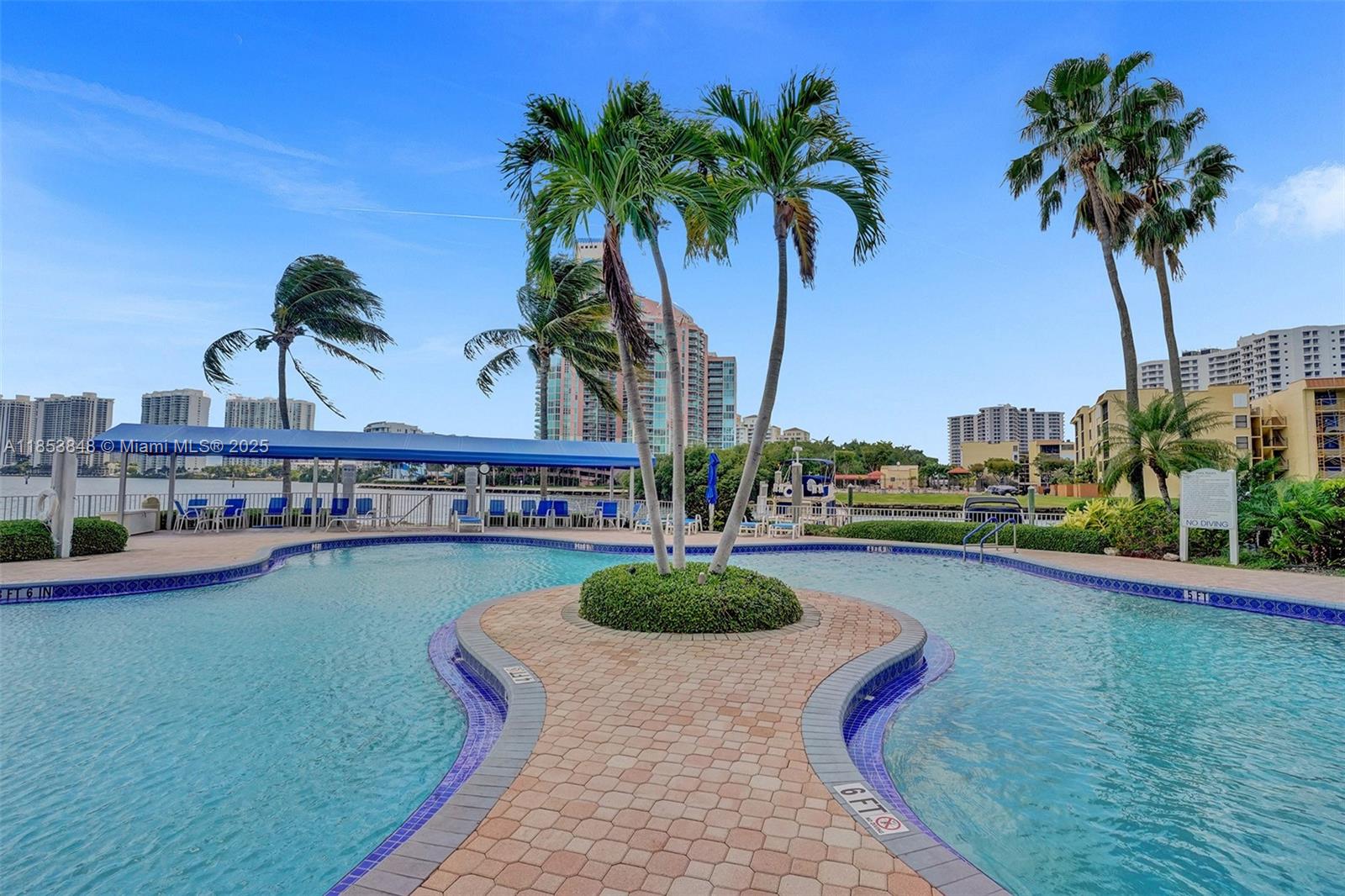 3530 Mystic Pointe Drive, Unit 2915 Aventura, FL 33180 - Photo 37 of 41 a swimming pool with outdoor seating and garden