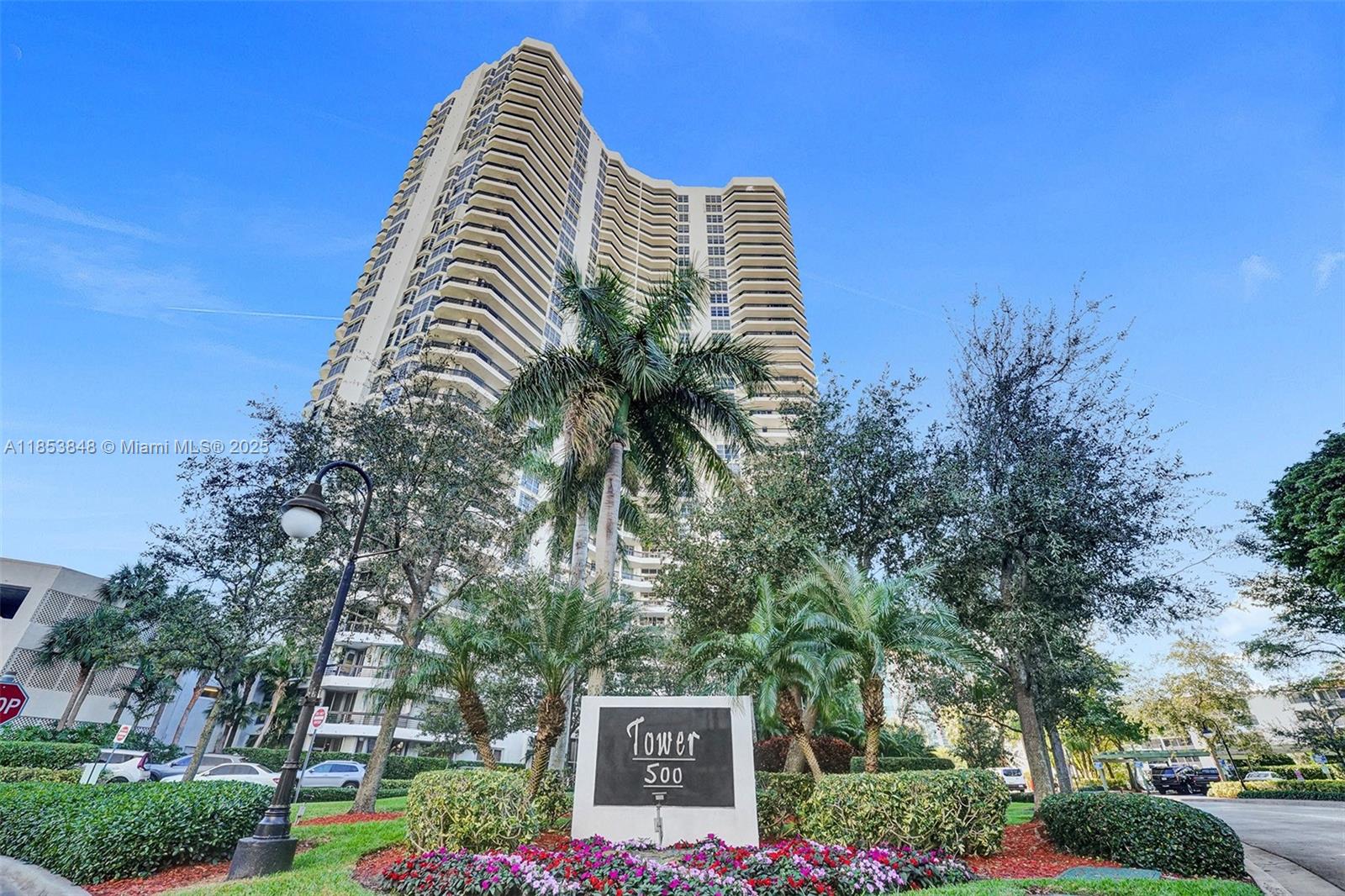 3530 Mystic Pointe Drive, Unit 2915 Aventura, FL 33180 - Photo 38 of 41 a view of a swimming pool with a bench and trees