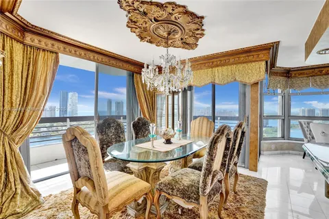 a dining room with furniture a chandelier and wooden floor